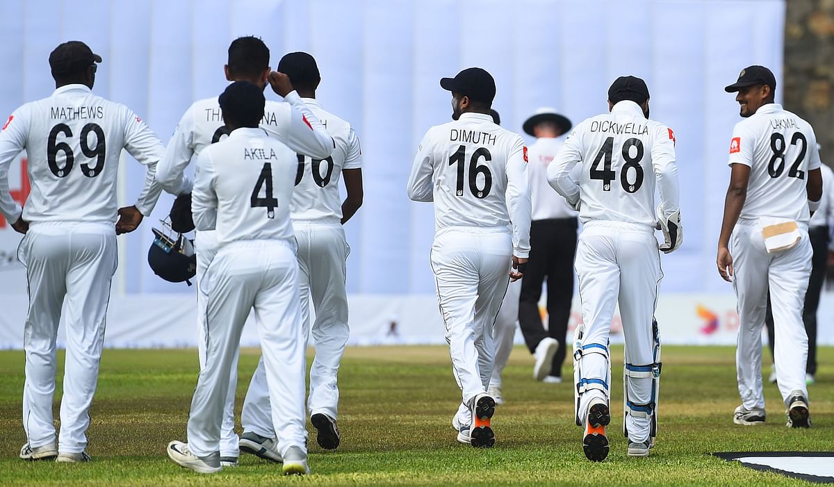 Sri Lankan cricket captain Dimuth Karunaratne (3R) with teammates walk on the field on the first day of the opening Test cricket match between Sri Lanka and New Zealand at the Galle International Cricket Stadium in Galle on 14 August 2019. Photo: AFP