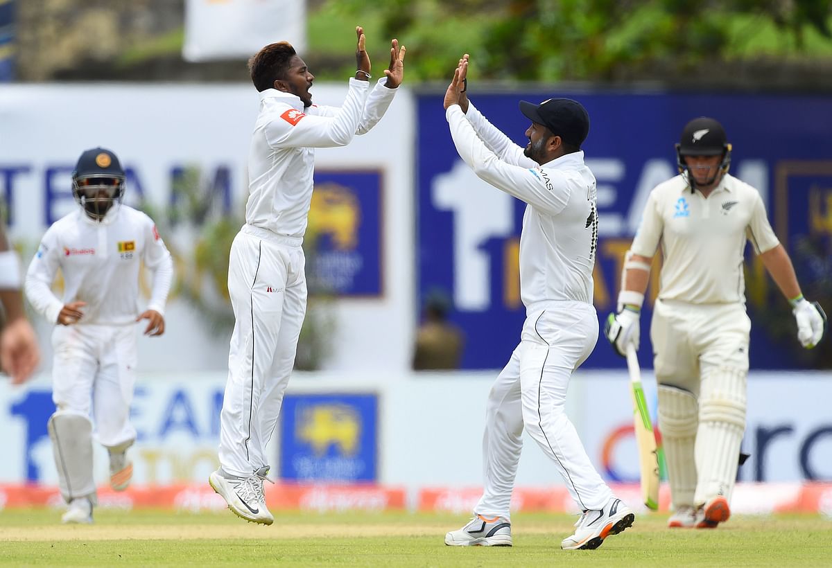 Sri Lankan cricketer Akila Dananjaya (2L) celebrates with teammates after dismissing New Zealand cricketer Tom Latham (R) during the first day of the opening Test cricket match between Sri Lanka and New Zealand at the Galle International Cricket Stadium in Galle on 14 August 2019. Photo: AFP