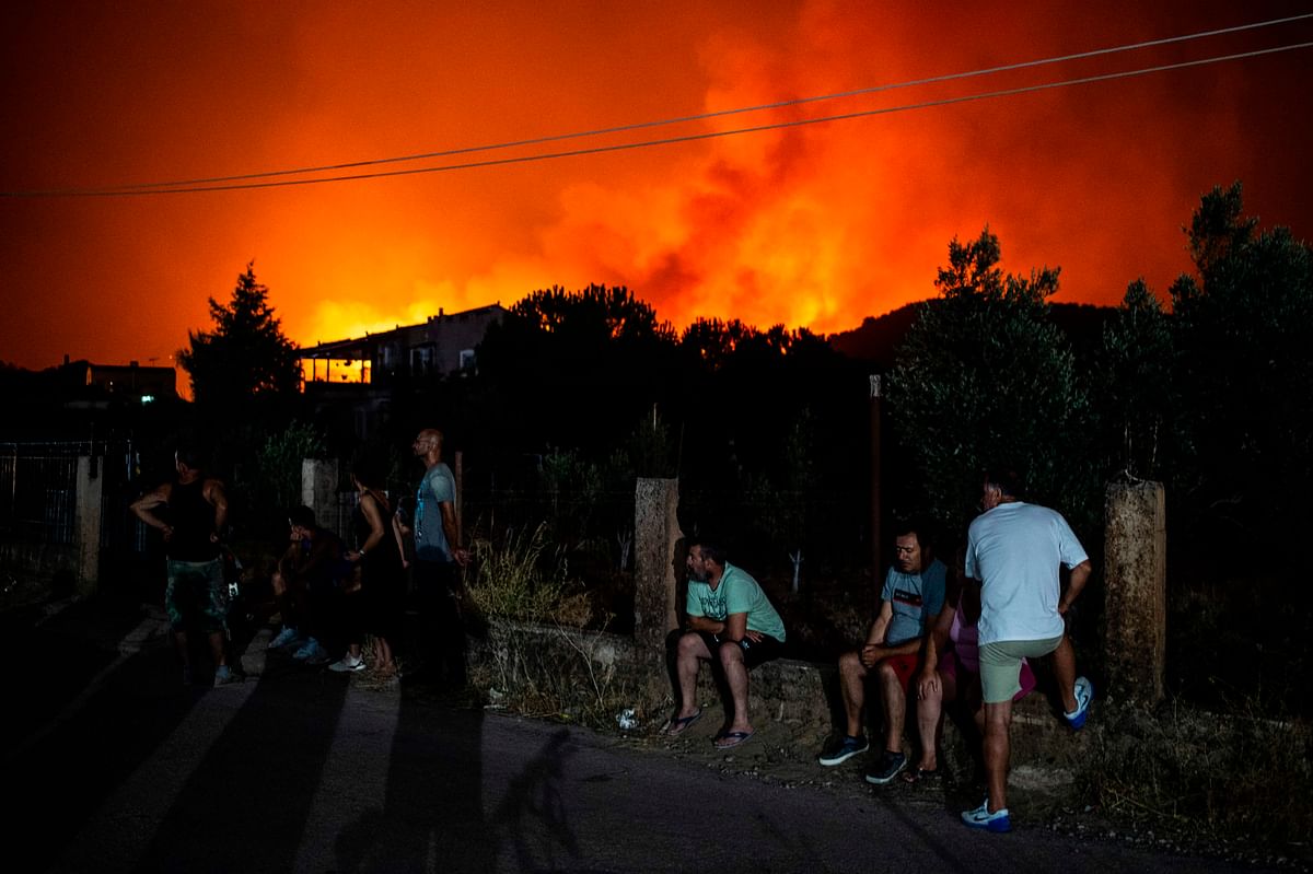 People wait to be evacuated from the Psachna village during a forest fire near the village of Makrimalli on the island of Evia, northeast of Athens, Greece on 13 August 2019. Photo: AFP