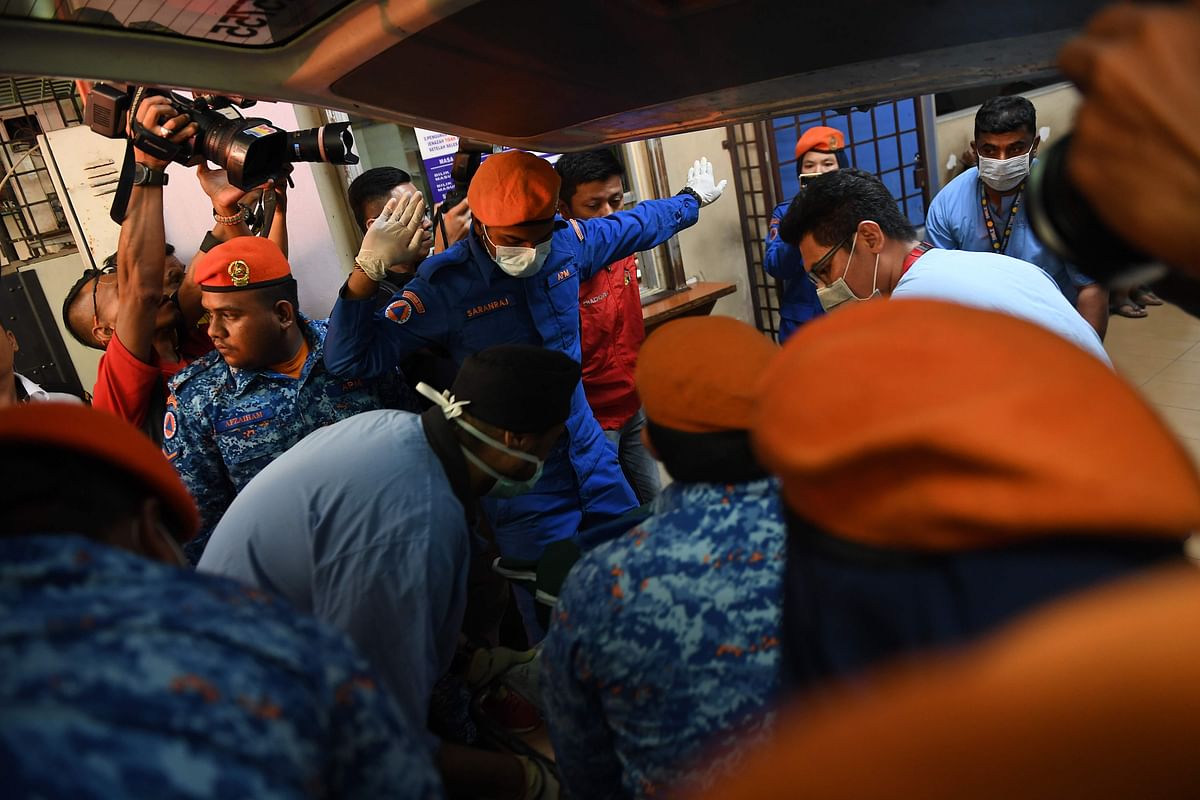 Rescue workers carry a body, found during a search operation for the missing 15-year-old Franco-Irish teenager Nora Quoirin, at a hospital in Seremban on 13 August 2019. Photo: AFP