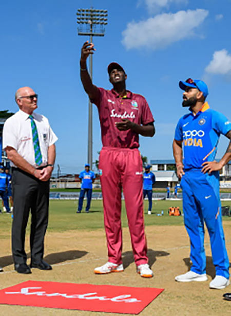 Port of Spain : Jason Holder © of West Indies tosses the coin as Virat Kohli ® of India and match referee Jeff Crowe (L) look on at the start of the 3rd ODI match between West Indies and India at Queens Park Oval, Port of Spain, Trinidad and Tobago, on Wednesday. Photo: AFP