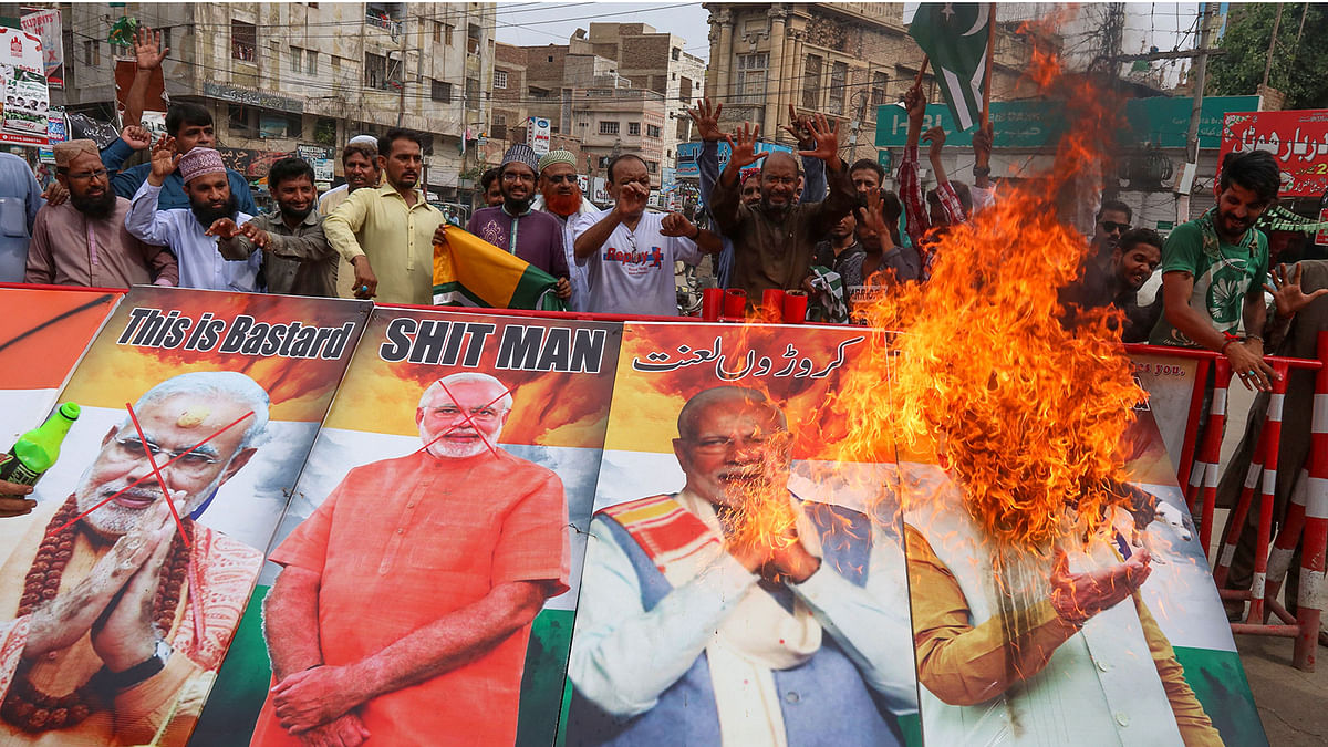 Protesters burn pictures of Indian prime minister Narendra Modi during a protest in Hyderabad on 15 August, 2019, as the country observes `Black Day` on India`s Independence Day over the recent move to strip Indian-administered Kashmir of its autonomy. Photo: AFP