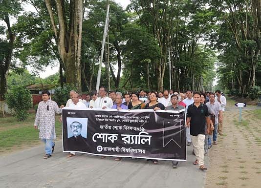Rajshahi University (RU) teachers and officials bring out a mourning rally on the campus on Thursday. Photo: BSS