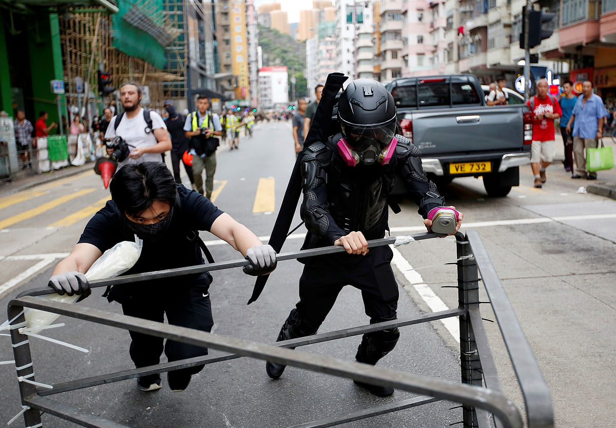 A protester nicknamed Ah Lung and another protester push a barricade to the frontline during a protest in Sham Shui Po neighbourhood of Hong Kong, China on 11 August 2019. Photo: Reuters