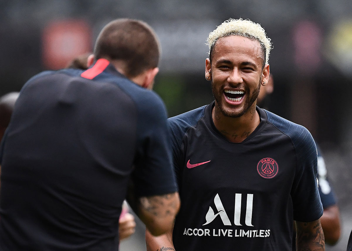 Paris Saint-Germain’s Brazilian forward Neymar ® jokes around as he takes part in a training session at the Shenzhen Universiade Stadium in Shenzhen on the eve of the French Trophy of Champions football match between Rennes and Paris Saint-Germain on 2 August.
