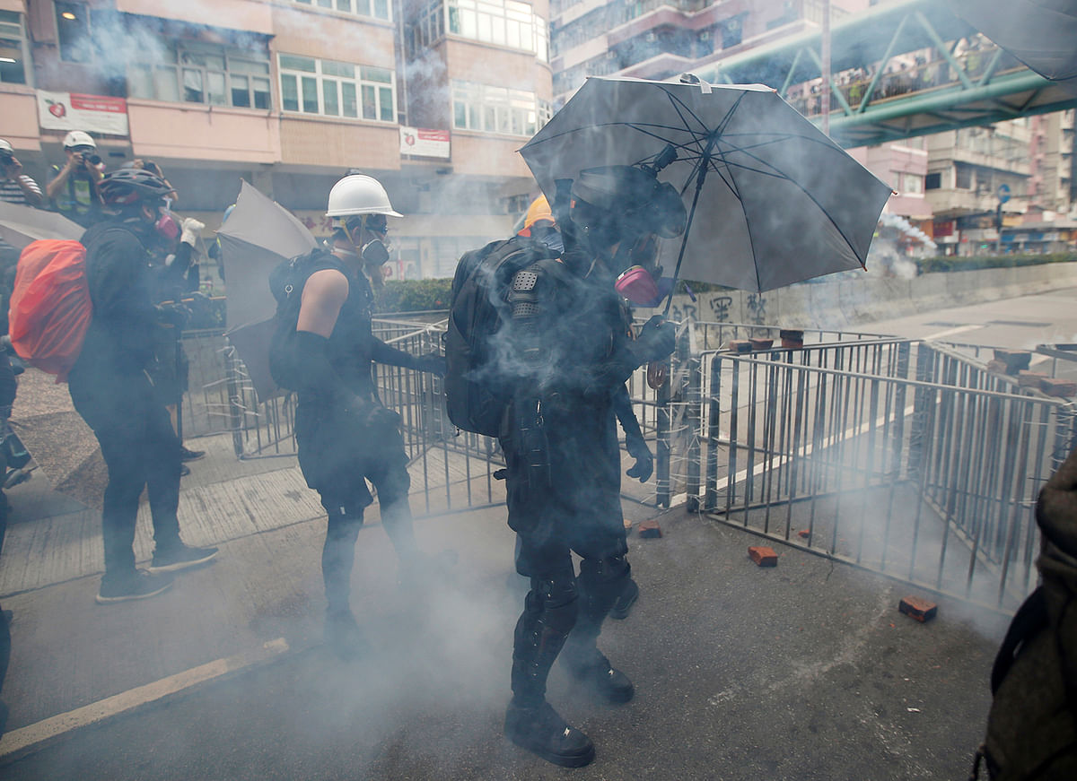 A protester nicknamed Ah Lung holds an umbrella amid tear gas as protesters clash with police officers in the Sham Shui Po neighbourhood in Hong Kong, China on 11 August 2019. Photo: Reuters