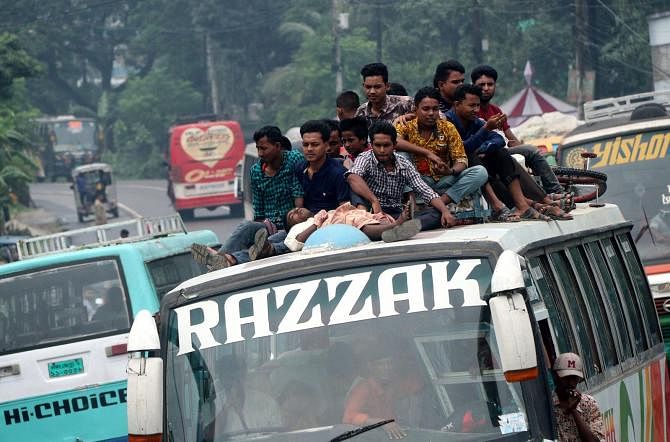 Vacationers risk their lives riding on to the roof of a bus on Bogura-Dhaka Highway in Bogura`s Shahjahanpur upazila on 16 Aug, 2019 while returning to Dhaka from their village homes after Eid-ul-Azha. Photo: Soel Rana