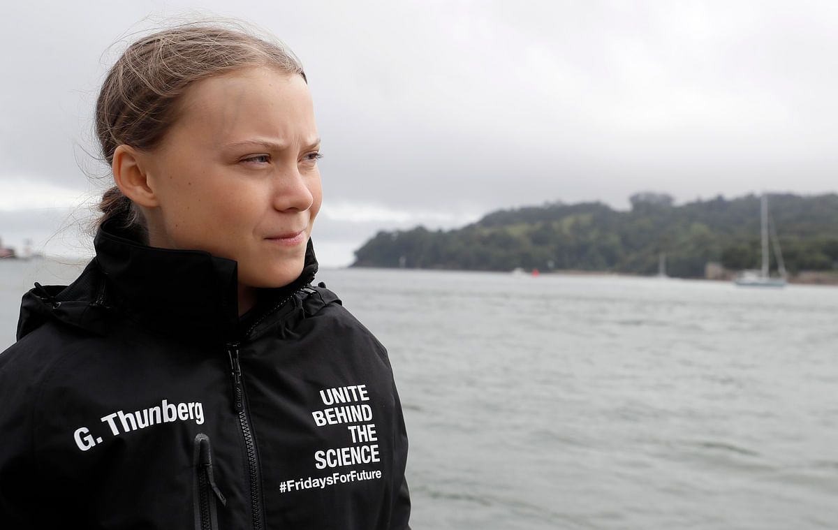 Swedish climate activist Greta Thunberg walks along the quayside to board an electric powered rib, before travelling to board the Malizia II IMOCA class sailing yacht off the coast of Plymouth, southwest England, on 14 August 2019, as she prepares to start her journey across the Atlantic to New York where she will attend the UN Climate Action Summit next month. Photo: AFP