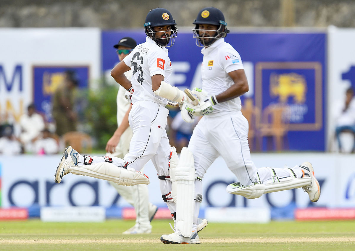 Sri Lanka`s cricket captain Dimuth Karunaratne (R) and Lahiru Thirimanne run between the wickets during the fourth day of the opening Test cricket match between Sri Lanka and New Zealand at the Galle International Cricket Stadium in Galle on 17 August, 2019. Photo: AFP