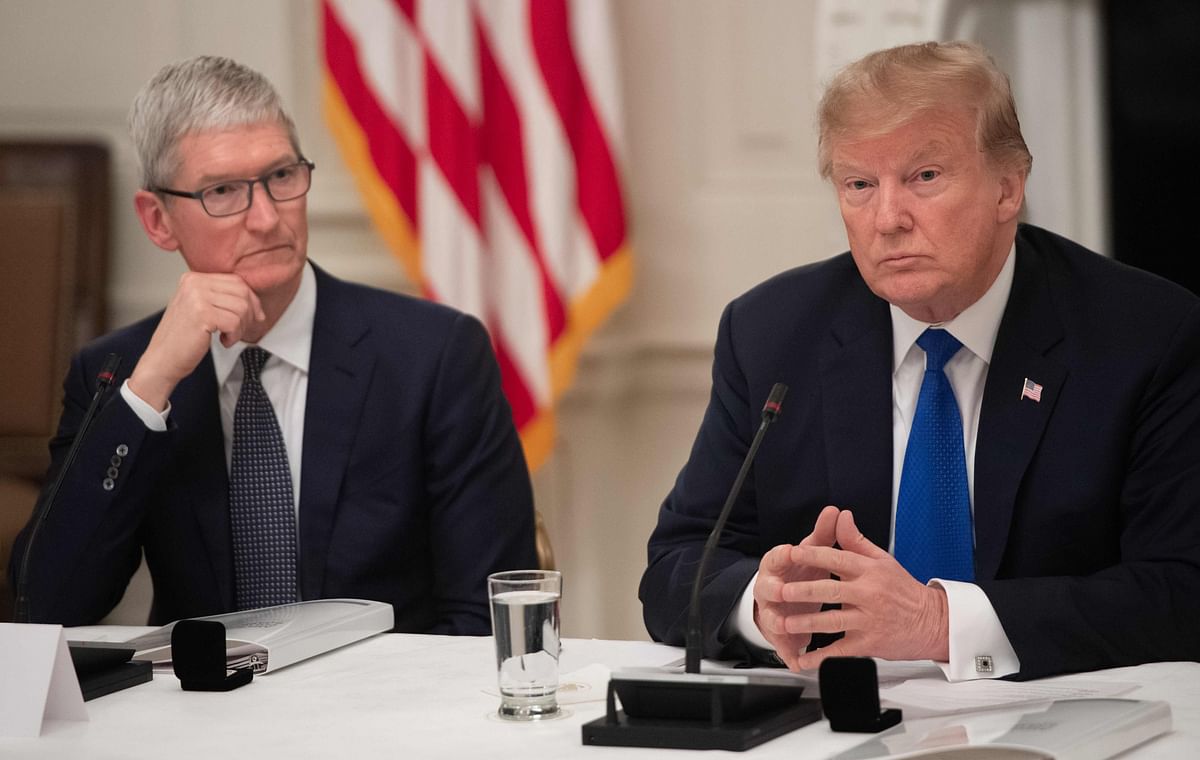 In this file photo taken on 06 March 2019 US president Donald Trump speaks alongside Apple CEO Tim Cook (L) during the first meeting of the American Workforce Policy Advisory Board in the State Dining Room of the White House in Washington, DC. Photo: AFP