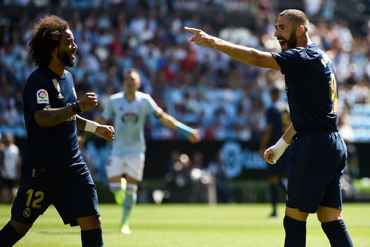 Real Madrid`s French forward Karim Benzema (R) celebrates with Real Madrid`s Brazilian defender Marcelo after scoring a goal during the Spanish League football match between Celta Vigo and Real Madrid at the Balaidos Stadium in Vigo on 17 August 2019. Photo: AFP