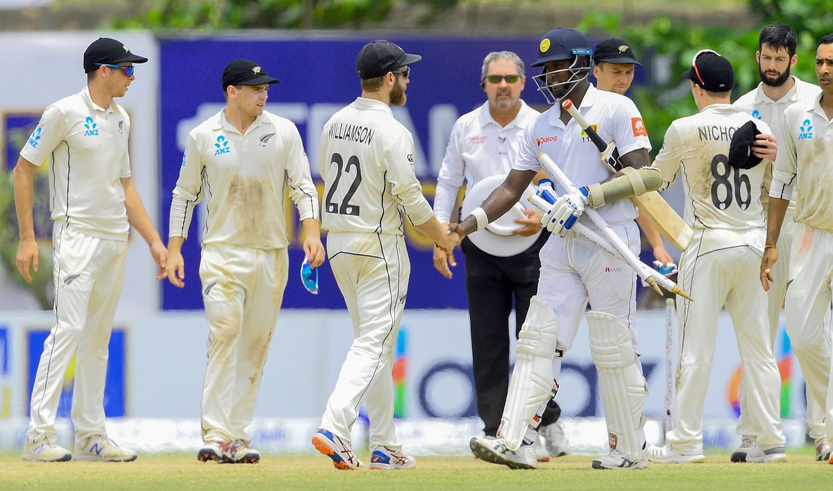 Sri Lanka`s cricketer Angelo Mathews (C-R) shakes hands with New Zealand`s cricket captain Kane Williamson (3L) after Sri Lanka beat New Zealand in first Test by six wickets during the final day of the opening Test cricket match between Sri Lanka and New Zealand at the Galle International Cricket Stadium in Galle on 18 August. Photo: AFP