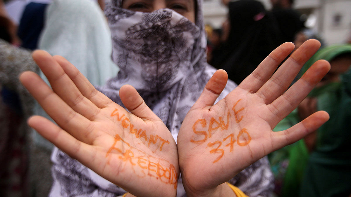 A Kashmiri woman shows her hands with messages at a protest after Friday prayers during restrictions after the Indian government scrapped the special constitutional status for Kashmir, in Srinagar on 16 August. Photo: Reuters