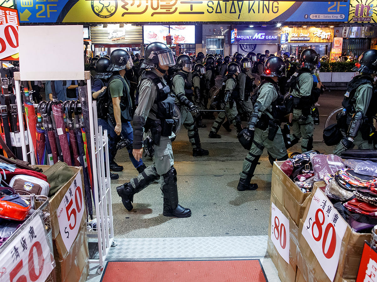 Riot police walk past a shop as they chase anti-government protesters down Nathan Road in Mong Kok in Hong Kong, China on 17 August. Photo: Reuters
