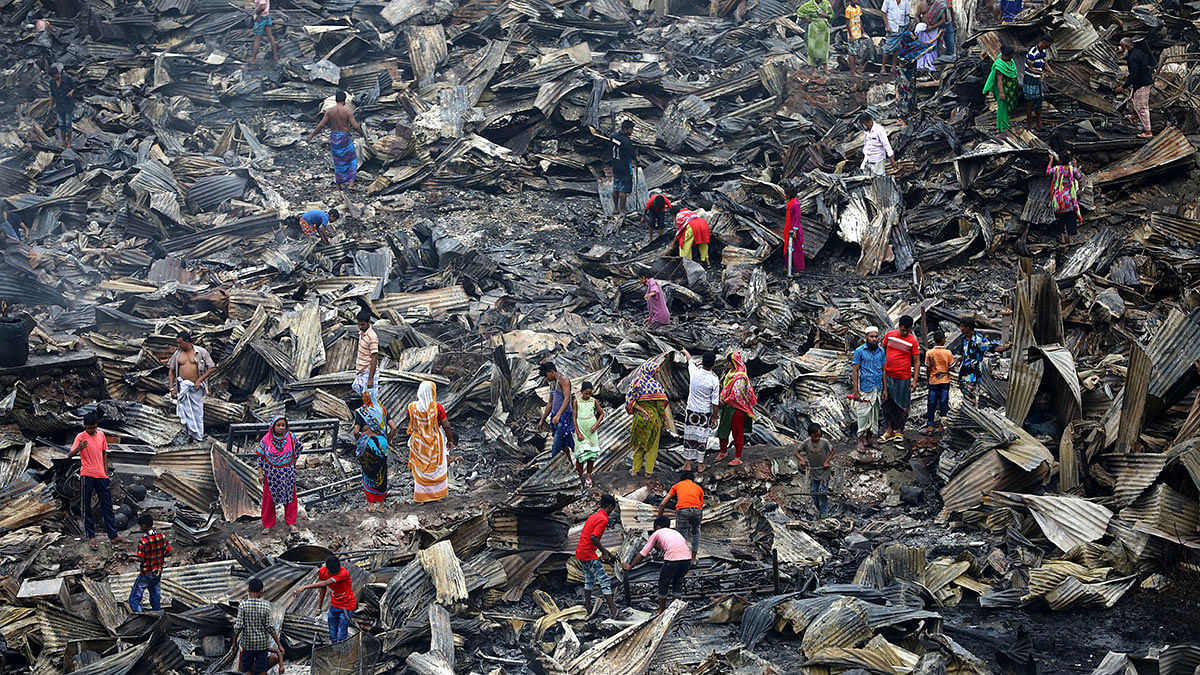 Slum dwellers are seen searching for their belongings from ashes after fire broke out on their shelters in Dhaka, Bangladesh, 17 August 2019. Photo: Reuters