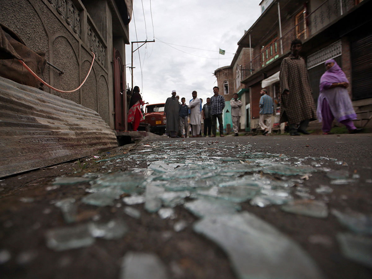 Kashmiris walk past broken window glass after clashes between protesters and the security forces on Friday evening, during restrictions following the scrapping of the special constitutional status for Kashmir by the Indian government, in Srinagar on 17 August 2019. Photo: Reuters