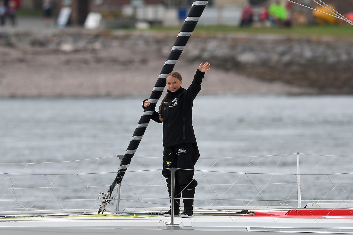 Swedish climate activist Greta Thunberg waves from aboard the Malizia II IMOCA class sailing yacht off the coast of Plymouth, southwest England, on 14 August 2019, as she starts her journey across the Atlantic to New York where she will attend the UN Climate Action Summit next month. Photo: AFP