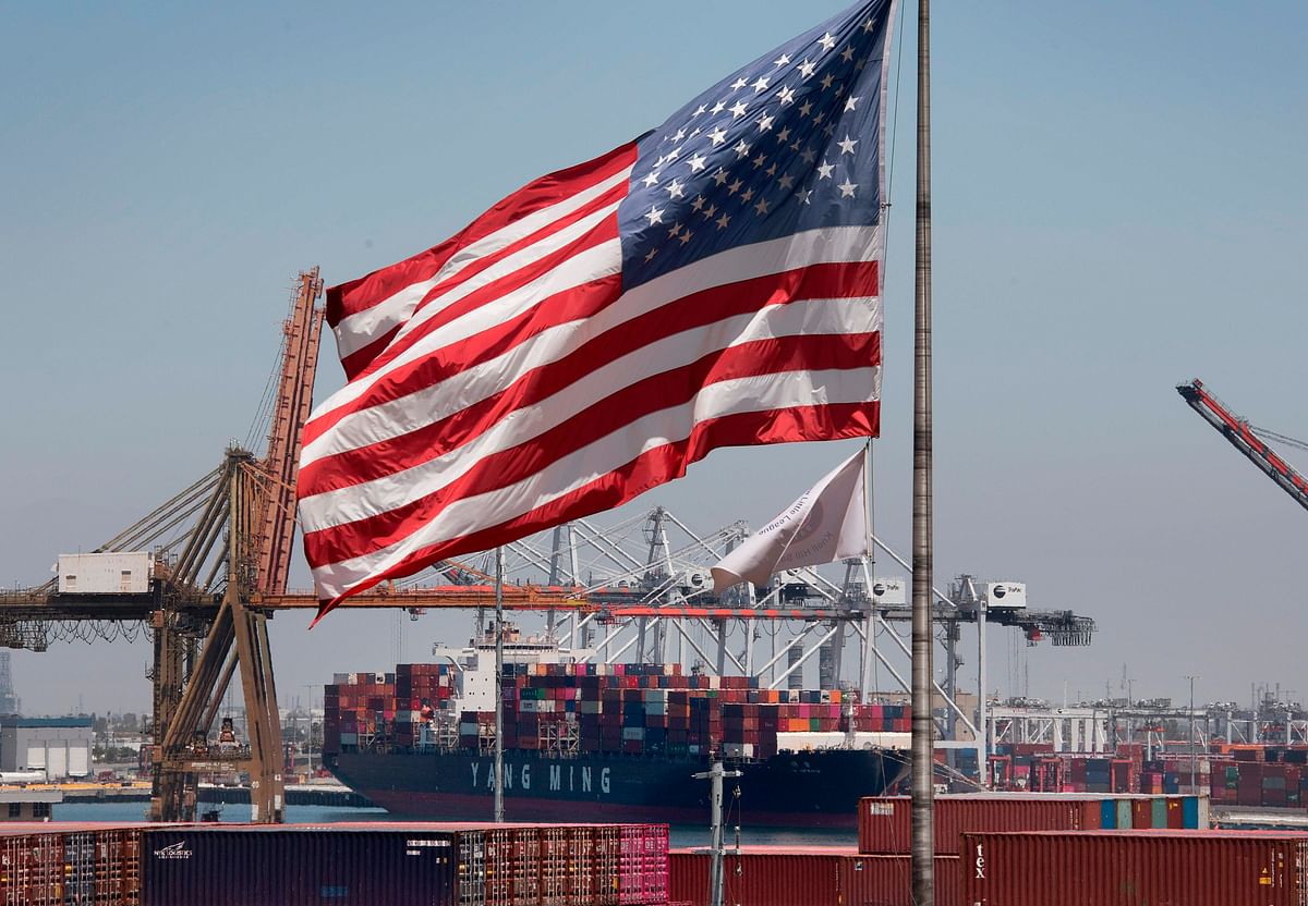 In this file photo taken on 1 August 2019 The US flag flies over a container ship unloading it`s cargo from Asia, at the Port of Long Beach, California. Photo: AFP
