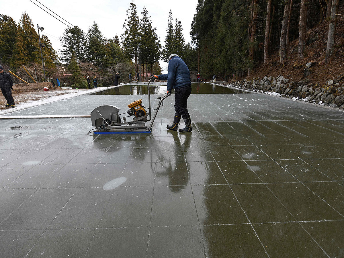 his picture taken on 10 January 2019 shows a worker cutting blocks of natural ice from an open-air pool at a factory in Nikko, Tochigi prefecture. Photo: AFP