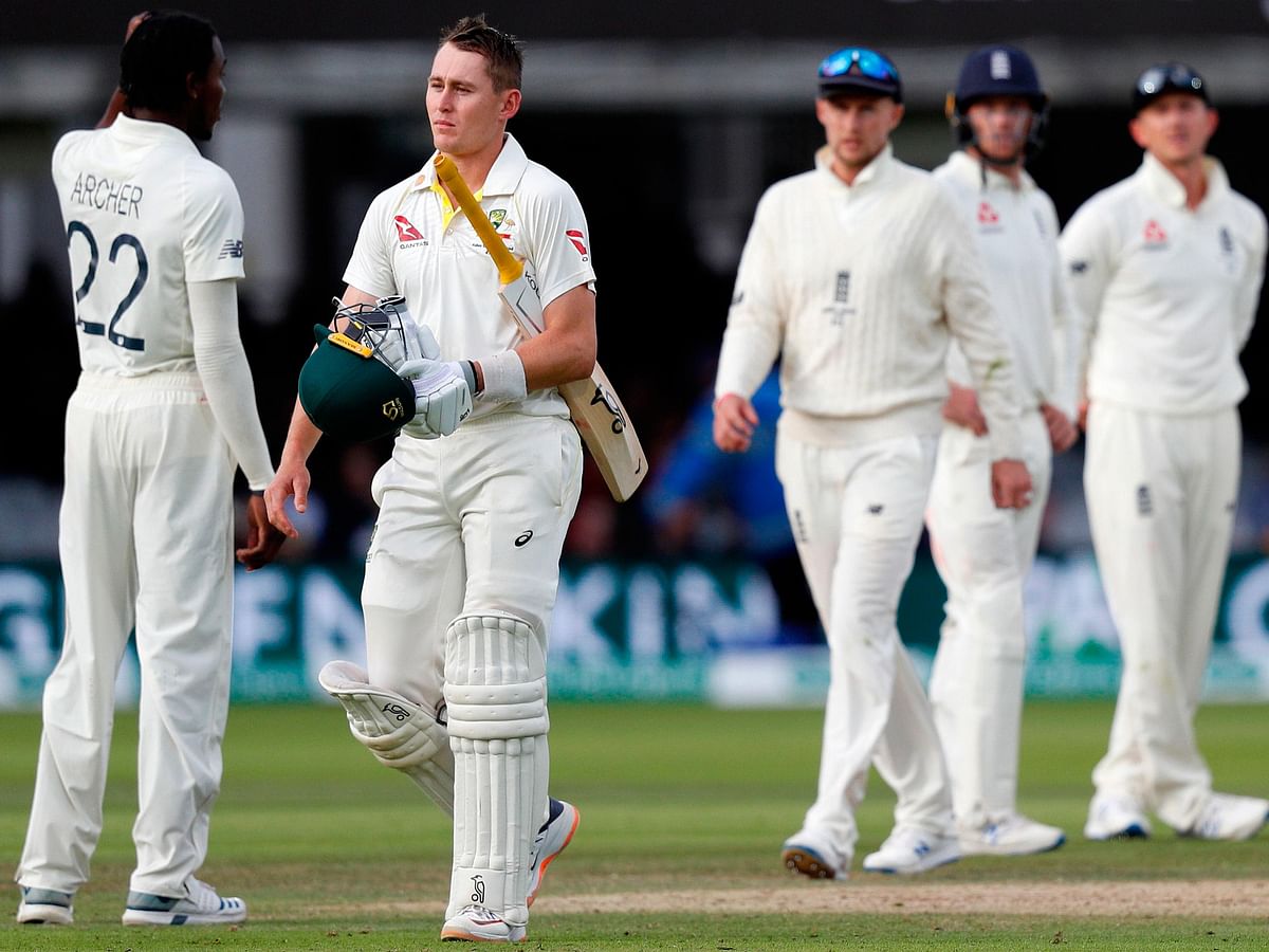 Australia`s Marnus Labuschagne (2L) walks back to the pavilion after losing his wicket for 59 runs to a catch from England`s captain Joe Root (C) during play on the fifth day of the second Ashes cricket Test match between England and Australia at Lord`s Cricket Ground in London on 18 August, 2019. Photo: AFP