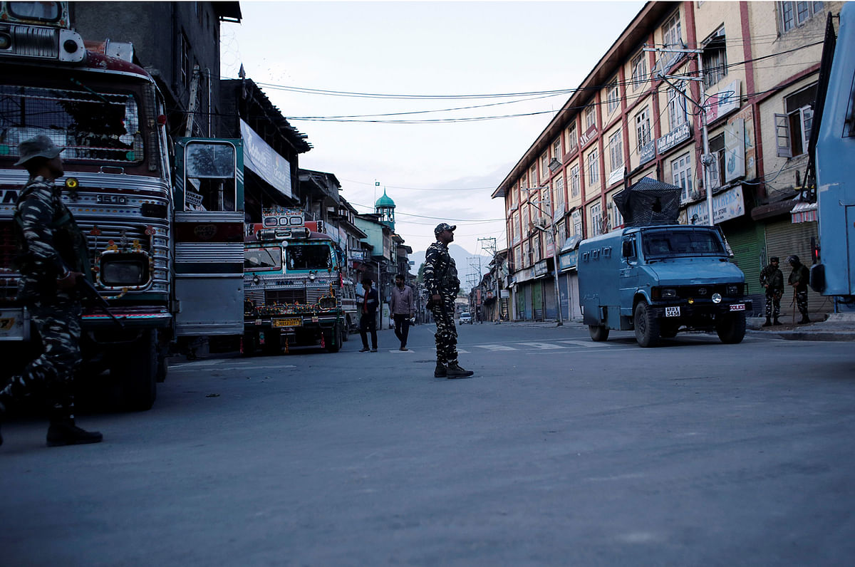 Indian security force personnel stand guard on a deserted road during restrictions after scrapping of the special constitutional status for Kashmir by the Indian government, in Srinagar, on 20 August 2019. Photo: Reuters