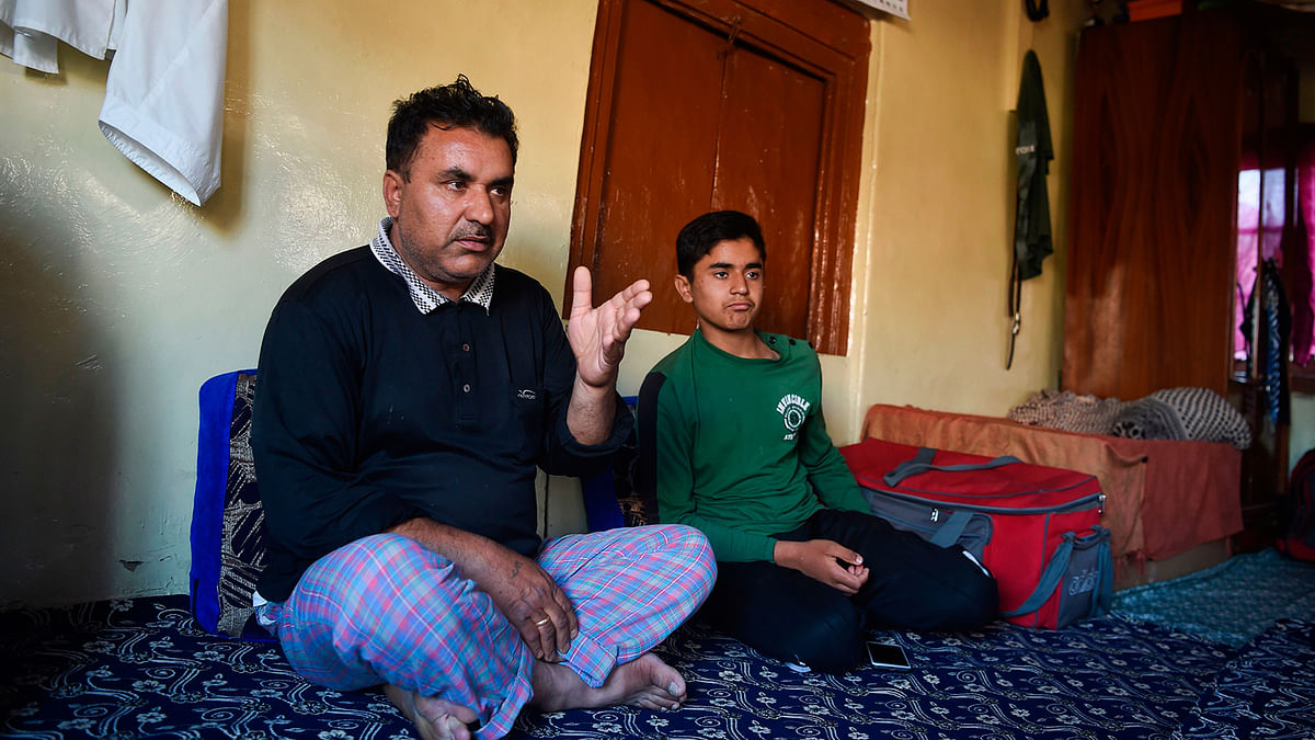 In this picture taken on 19 August 2019 Kashmiri father Mohammad Saleem speaks with AFP as his son Shayan (R) looks on during an interview in their home in Srinagar. Photo: AFP
