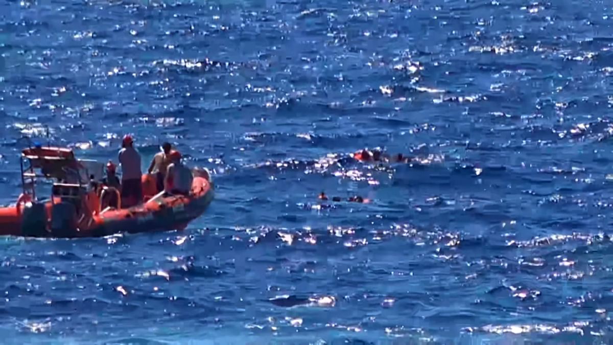 This grab from a video taken by Local Team shows migrants rescued for days by NGO Proactiva Open Arms charity ship, being rescued by a Spanish patrol boat after throwing themselves in the water to try and swim to the nearby Italian island of Lampedusa in a desperate move after days stuck on board, on 20 August 2019. Photo: AFP