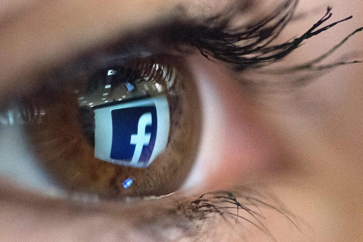 In this file photo taken on 22 March 2018 An illustration picture taken on 22 March 2018 in Paris shows a close-up of the Facebook logo in the eye of an AFP collaborator posing while she looks at a flipped logo of Facebook. Photo: AFP