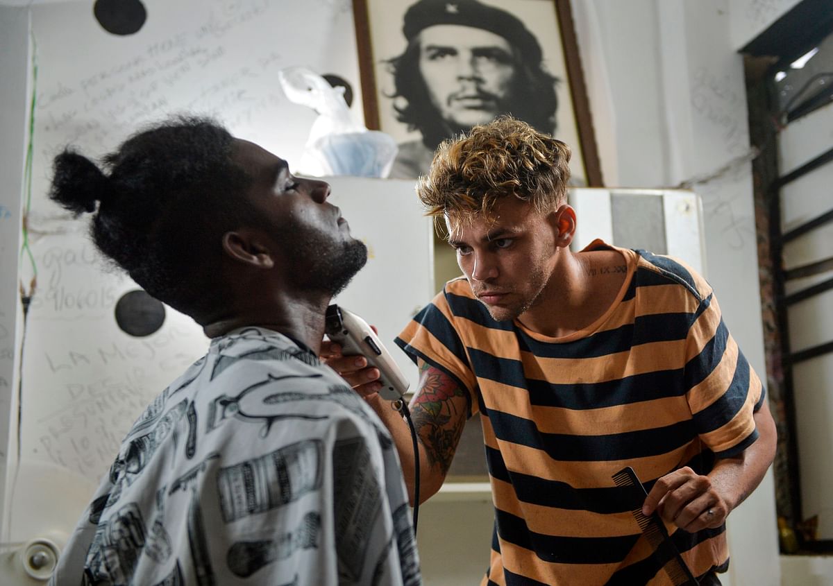 A barber cuts a client beard in a barbershop of Havana, on 7 August 2019. Photo: AFP