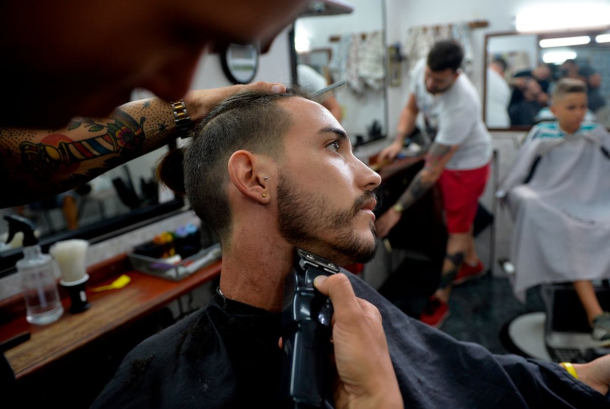 A barber cuts a client beard in a barbershop of Havana, on 12 July 2019. Photo: AFP