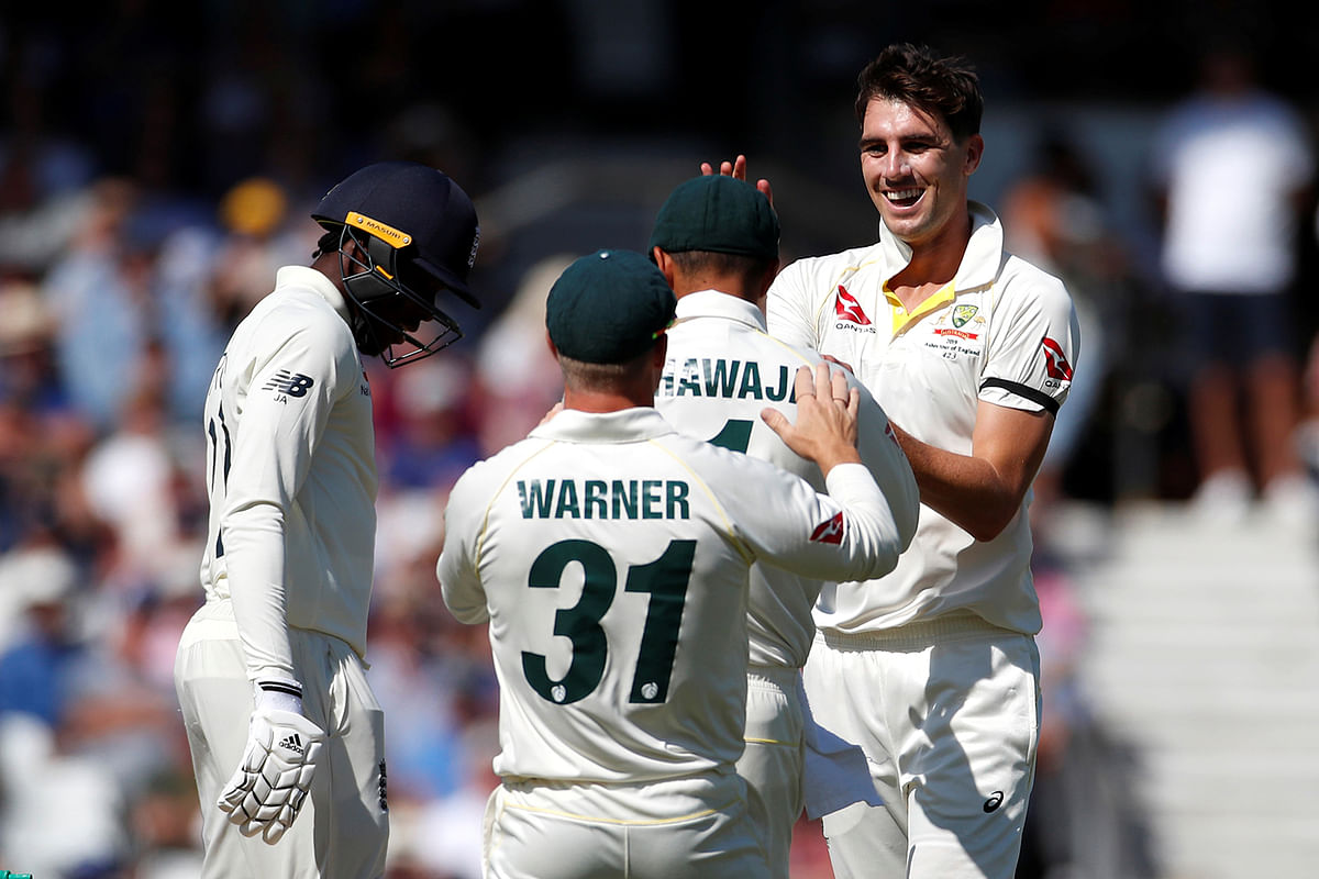 Australia`s Pat Cummins celebrates with teammates after taking the wicket of England`s Jofra Archer. Photo: Reuters