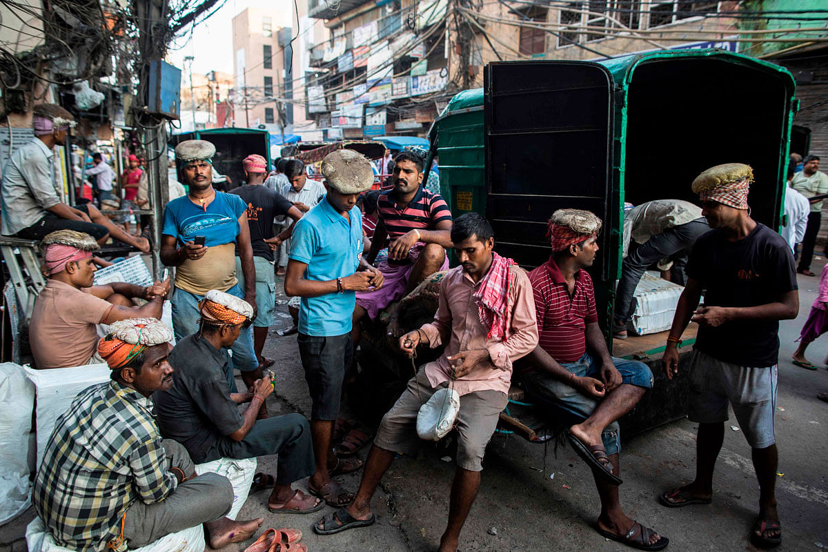 Workers take a break along a street at Chawri Bazar in the old quarters of New Delhi on 19 August 2019. Photo: AFP