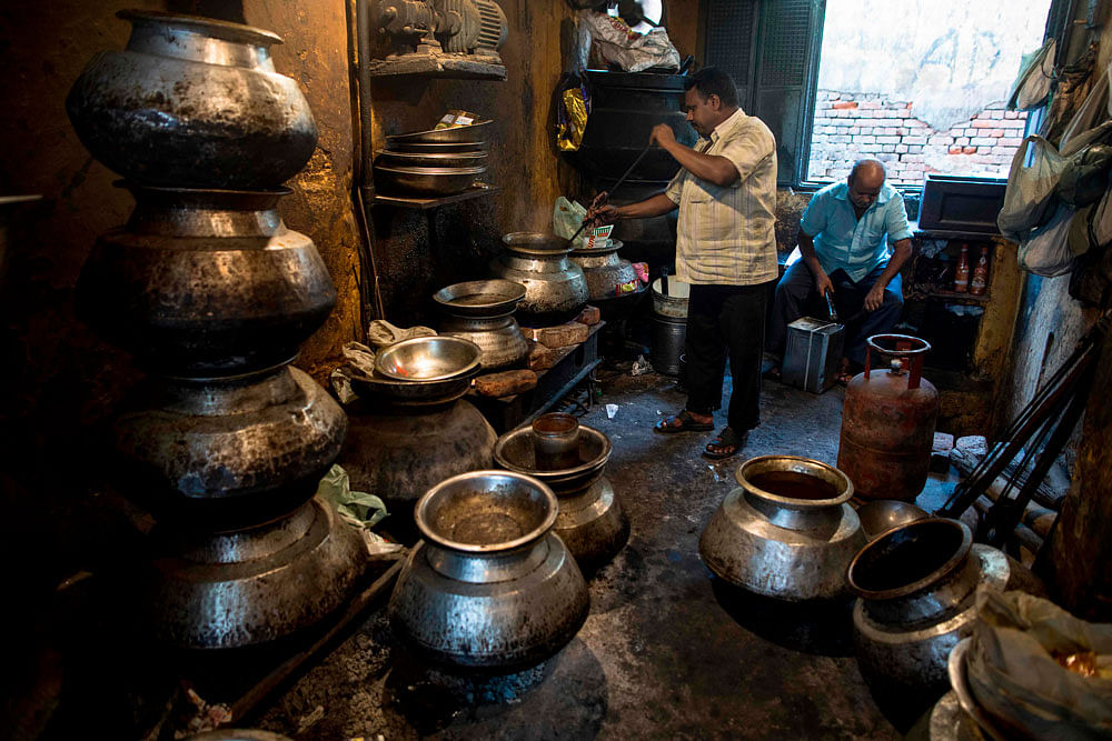 A worker steers a pot at a take-away Mughal food shop in Chawri Bazar in the old quarters of New Delhi on 19 August 2019. Photo: AFP