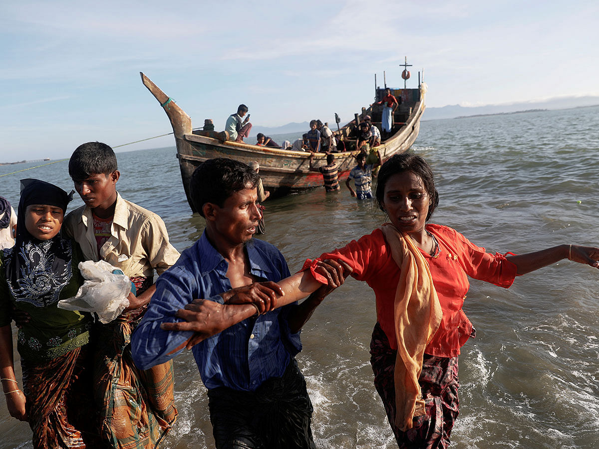 Shakira, a 22 year old Rohingya is helped as refugees arrive by a wooden boat from Myanmar to the shore of Shah Porir Dwip, in Teknaf, near Cox`s Bazar in Bangladesh, on 1 October 2017. Reuters File Photo