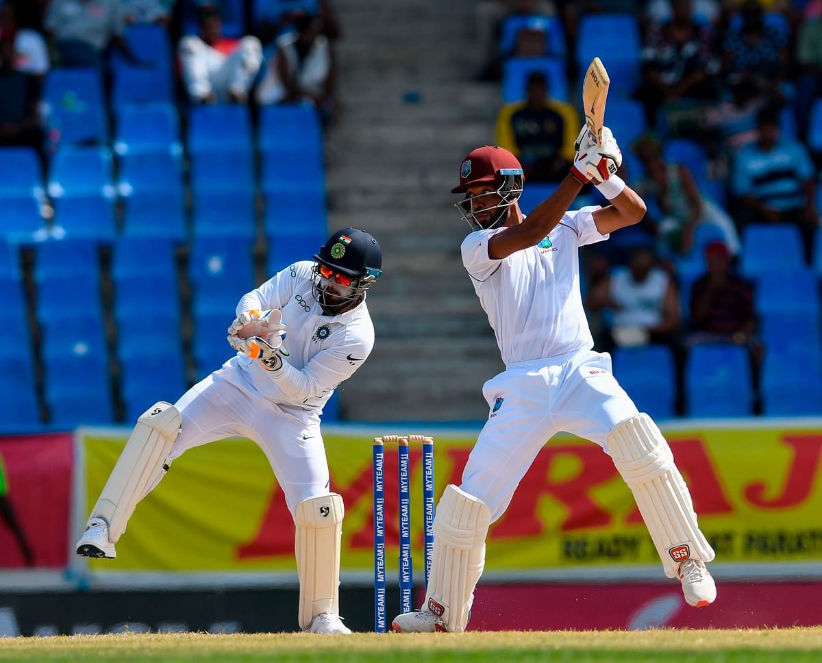 Roston Chase (R) of West Indies hits 4 as Rishabh Pant (L) of India look on during day 2 of the 1st Test between West Indies and India at Vivian Richards Cricket Stadium in North Sound, Antigua and Barbuda, on 23 August 2019. Photo: AFP