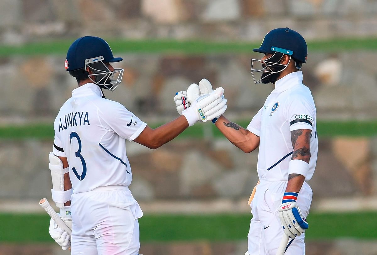 Ajinkya Rahane (L) congratulates Virat Kohli (R) of India for his half century during day 3 of the 1st Test between West Indies and India at Vivian Richards Cricket Stadium in North Sound, Antigua and Barbuda, on 24 August 2019. Photo: AFP
