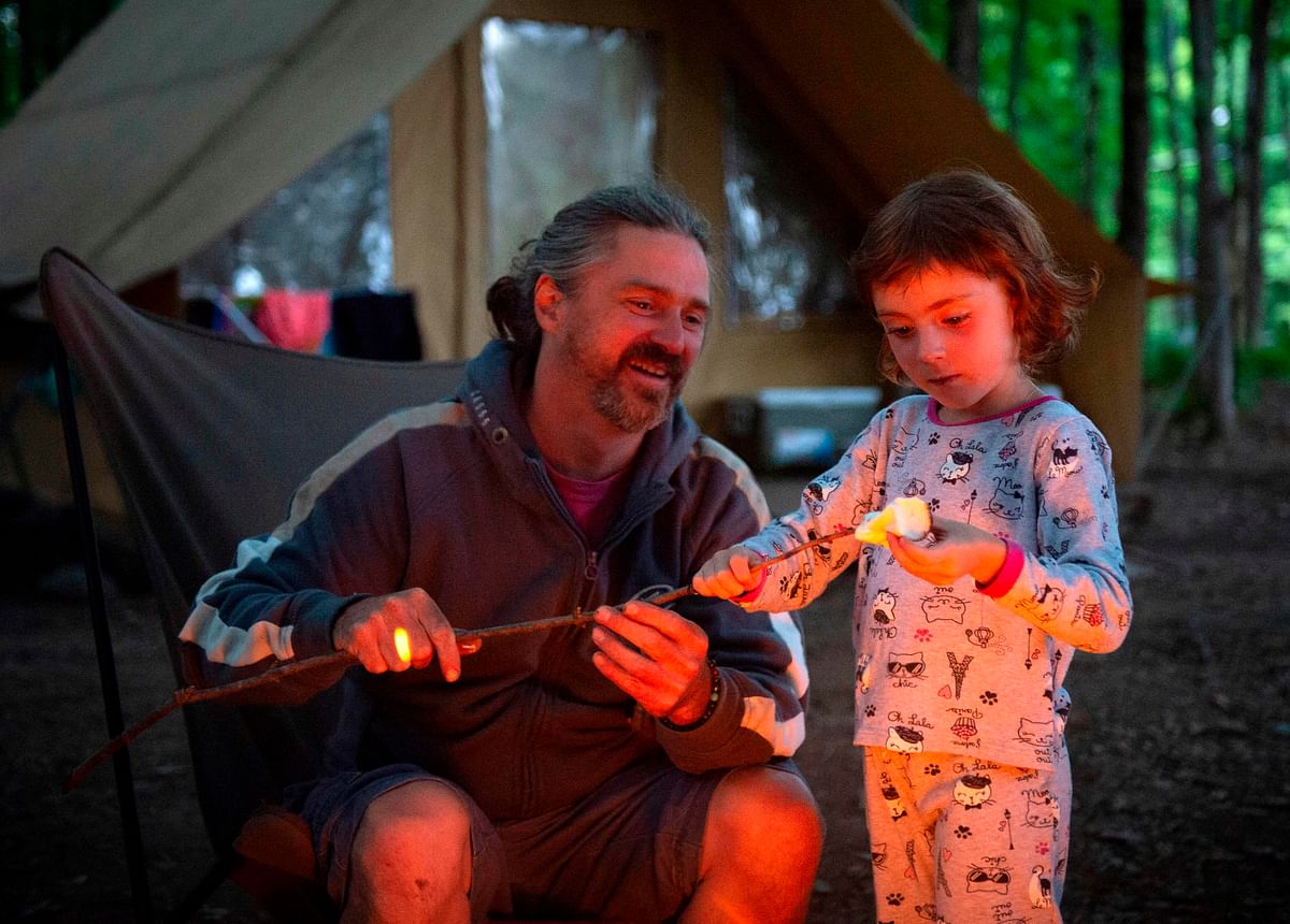 A family enjoys a campfire at the Huttopia Sutton glamping ground in Quebec, Canada, on 14 August 2019. Photo: AFP