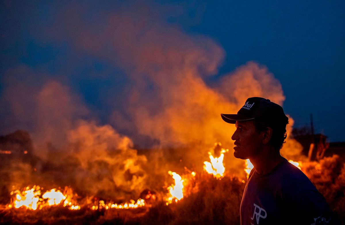 A labourer stares at a fire that spread to the farm he work on next to a highway in Nova Santa Helena municipality in northern Mato Grosso State, south in the Amazon basin in Brazil, on 23 August. Photo: AFP