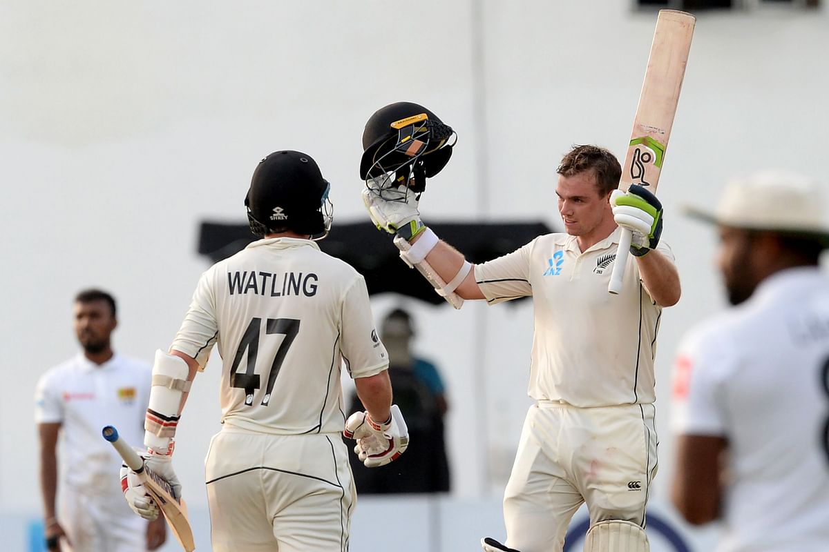 New Zealand`s cricketer Tom Latham (R) raises his bat and helmet in celebration after scoring a century (100 runs) as his teammate BJ Watling (L) looks on during the third day of the final cricket Test match between Sri Lanka and New Zealand at P. Sara Oval cricket stadium in Colombo on 24 August 2019. Photo: AFP