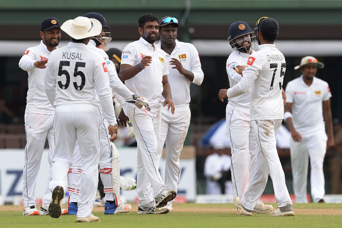 Sri Lankan cricketer Dilruwan Perera (C) celebrates with teammates after he dismissed New Zealand`s cricketer Henry Nicholls during the third day of the final cricket Test match between Sri Lanka and New Zealand at P. Sara Oval cricket stadium in Colombo on 24 August 2019. Photo: AFP