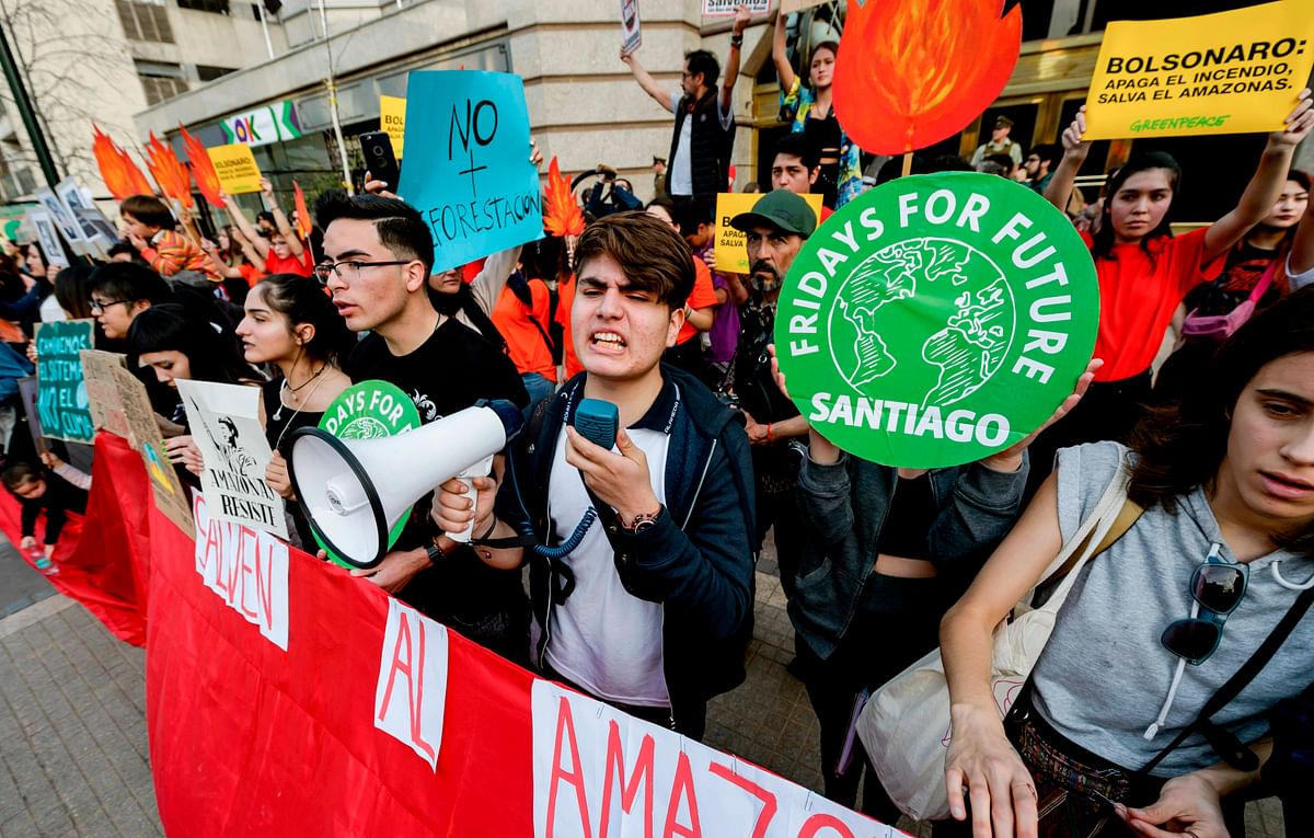 Activists demonstrate during a protest against the government of Brazil`s president Jair Bolsonaro over the fires in the Amazon rainforest in front of Brazil`s Embassy in Santiago on 23 August 2019. Photo: AFP
