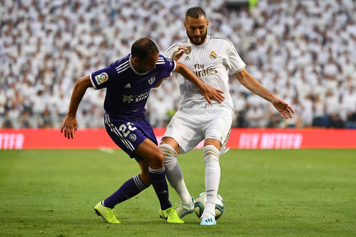 Valladolid`s Spanish defender Nacho (L) challenges Real Madrid`s French forward Karim Benzema during the Spanish League football match at the Santiago Bernabeu stadium in Madrid on 24 August 2019. Photo: AFP