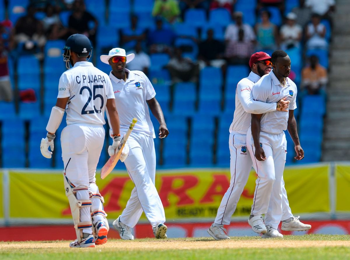 Kemar Roach (R) and John Campbell (2R) of West Indies celebrate the dismissal of Cheteshwar Pujara (L) of India during day 3 of the 1st Test between West Indies and India at Vivian Richards Cricket Stadium in North Sound, Antigua and Barbuda, on 24 August 2019. Photo: AFP