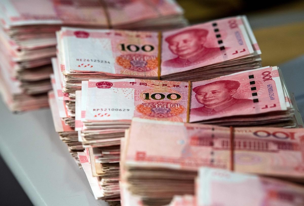 This file photo taken on 8 August 2018 shows bundles of 100 yuan (14.6 USD) notes at a bank in Shanghai. China`s currency on 26 August slid to its lowest point in more than 11 years as concerns over the US trade war and the potential for global recession weighed on markets. Photo: AFP