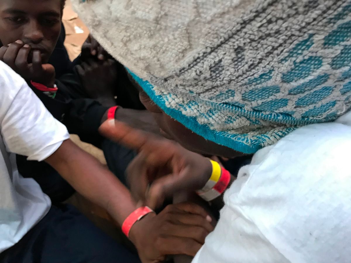 In this photograph taken on 23 August 2019, `Omar` (R) speaks with fellow migrants after he was reunited with US nurse Maryjo aboard the `Ocean Viking` rescue ship, jointly operated by French NGOs SOS Mediterranee and Medecins sans Frontieres (MSF Doctors without Borders) on 23 August 2019, at sea after a search-and-rescue operation in the Mediterranean Sea. Photo: AFP
