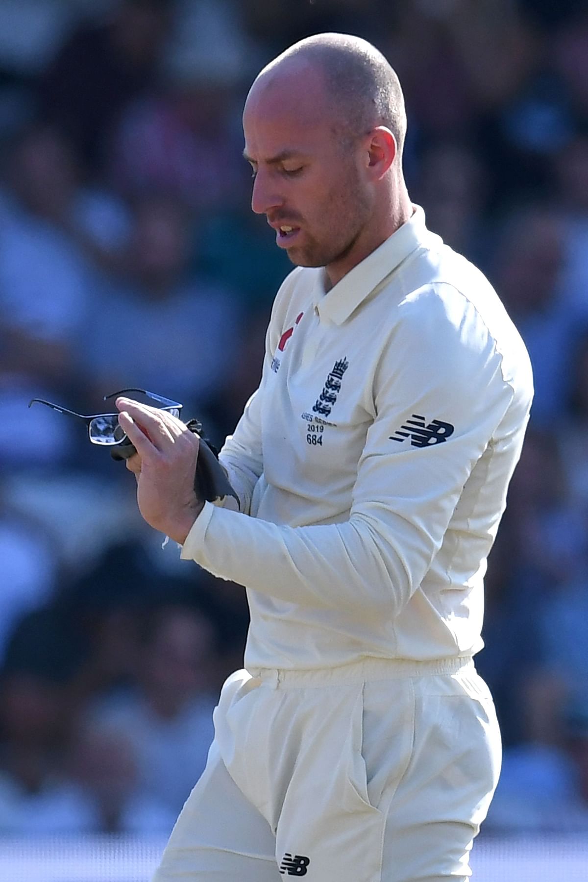 England`s Jack Leach cleans his glasses during a break in play on the fourth day of the third Ashes cricket Test match between England and Australia at Headingley in Leeds, northern England, on 25 August 2019. Photo: AFP