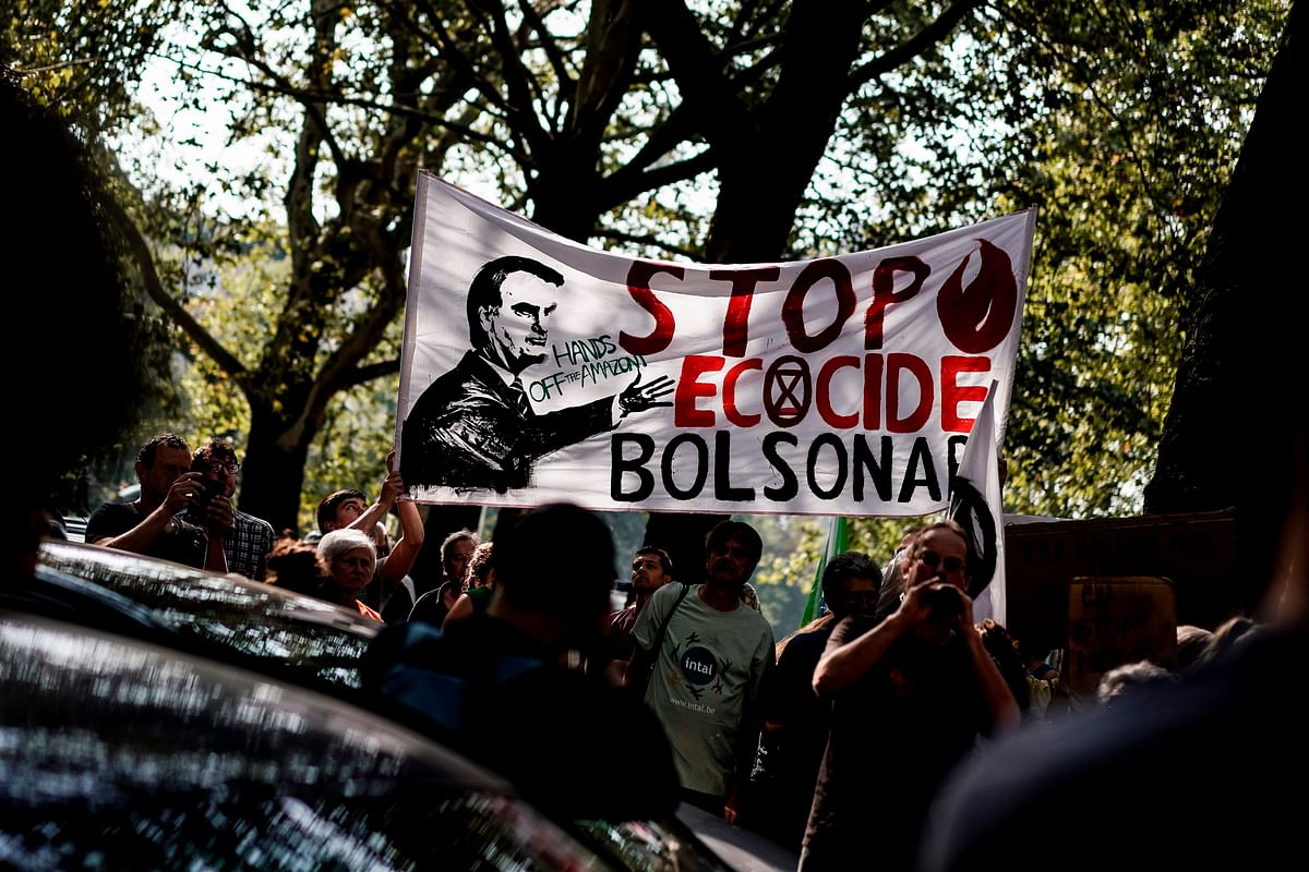 Protesters hold a banner as they gather in front of the Brazilan Embassy for a demonstration organised by Extinction Rebellion activists in Brussels, 26 August 2019, calling on Brazil to act to protect the Amazon rainforest from deforestation and fire. Photo: AFP