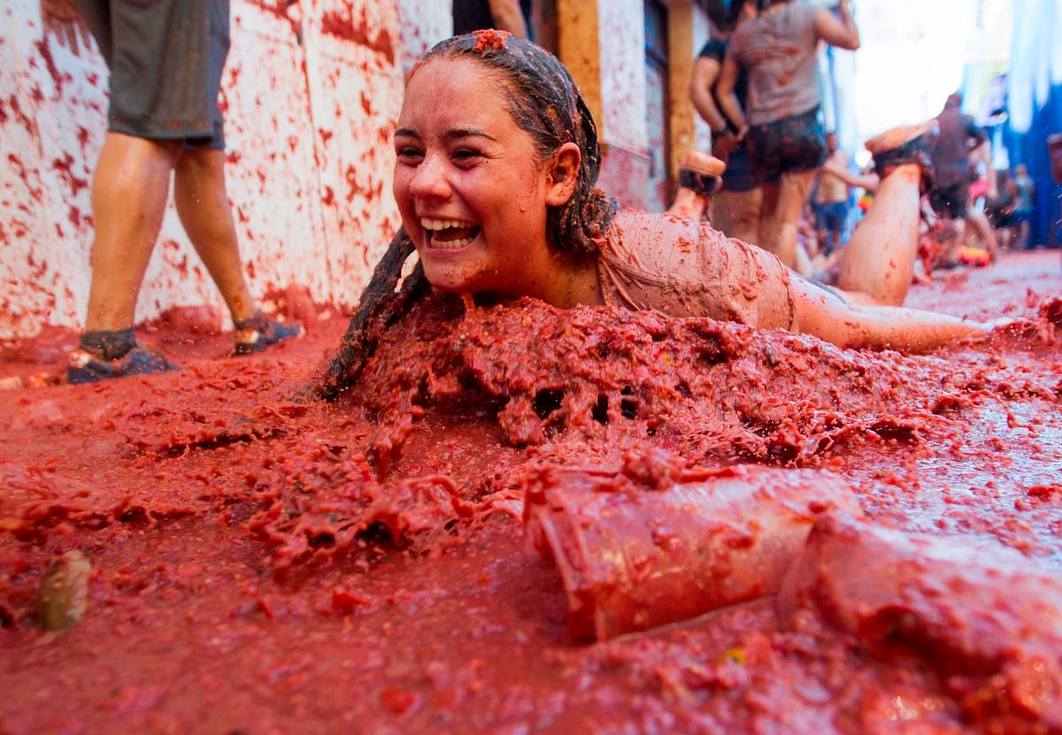 A reveller covered in tomato pulp takes part in the annual `Tomatina` festival in the eastern town of Bunol, on 28 August 2019. Photo: AFP