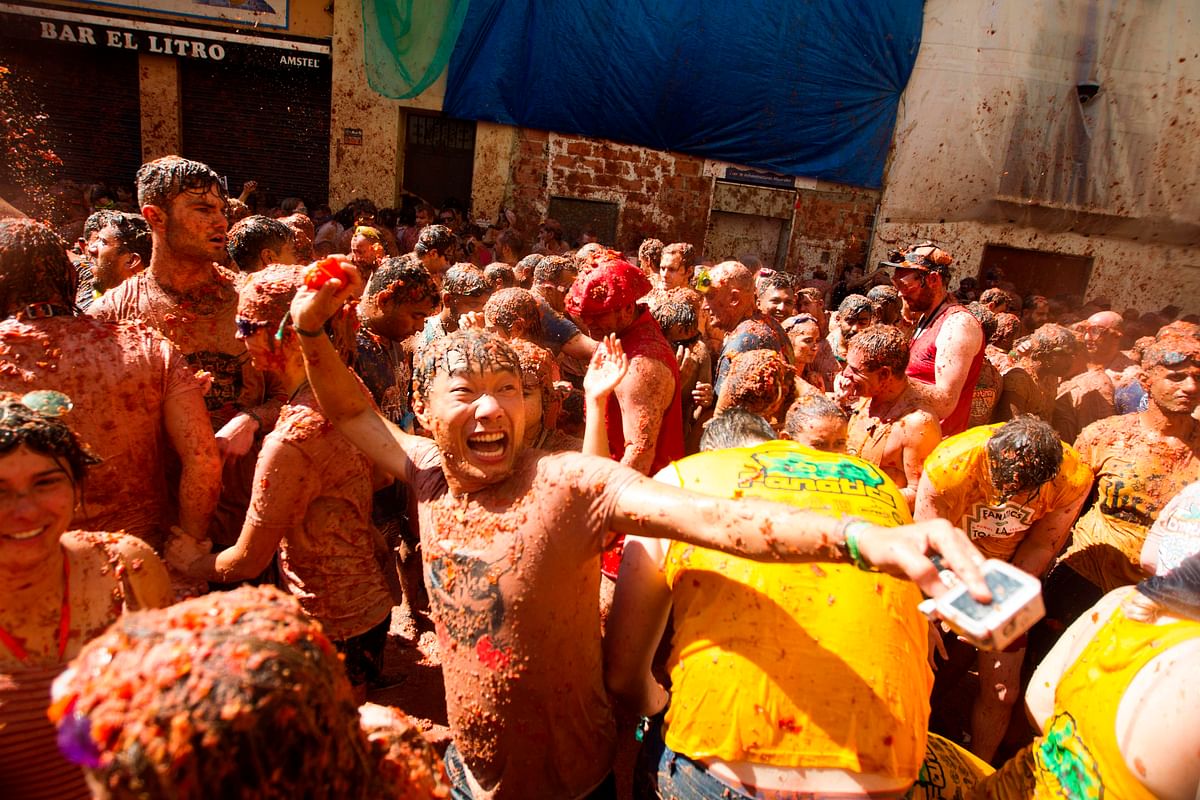 Revellers covered in tomato pulp take part in the annual `Tomatina` festival in the eastern town of Bunol, on 28 August 2019. The iconic fiesta, which is billed at `the world`s biggest food fight` has become a major draw for foreigners, in particular from Britain, Japan and the United States. Photo: AFP