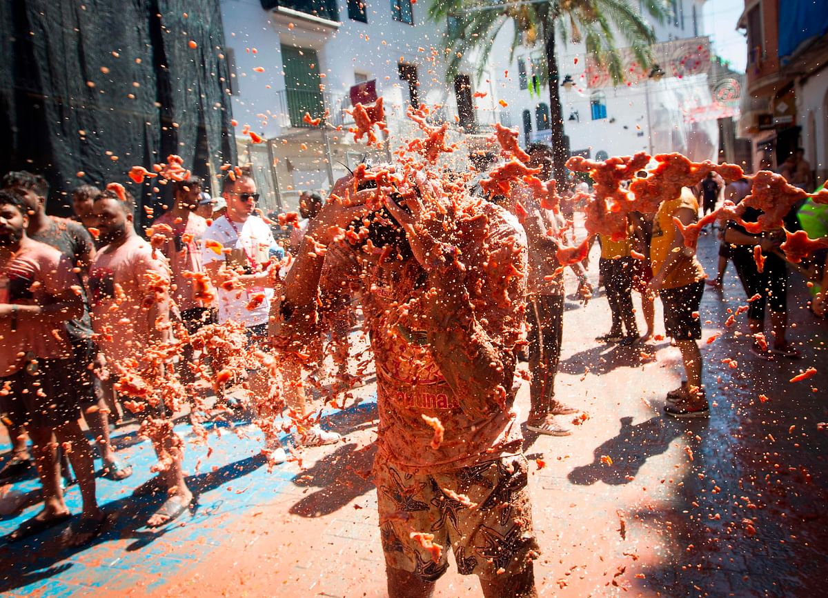A reveller covered in tomato pulp takes part in the annual `Tomatina` festival in the eastern town of Bunol, on 28 August 2019. Photo: AFP